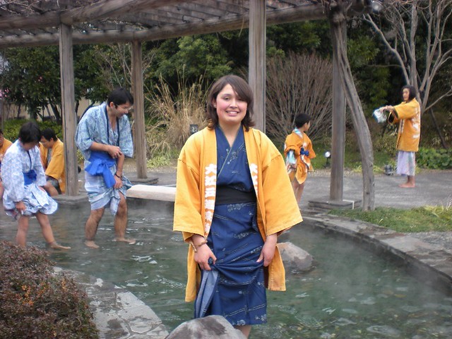 Mary Alania in a kimono wading in a pond.