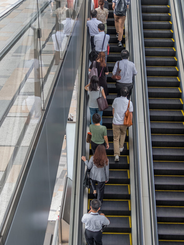 TOKYO, JAPAN - SEPTEMBER 1ST, 2017. People riding an escalator in Tokyo Station.